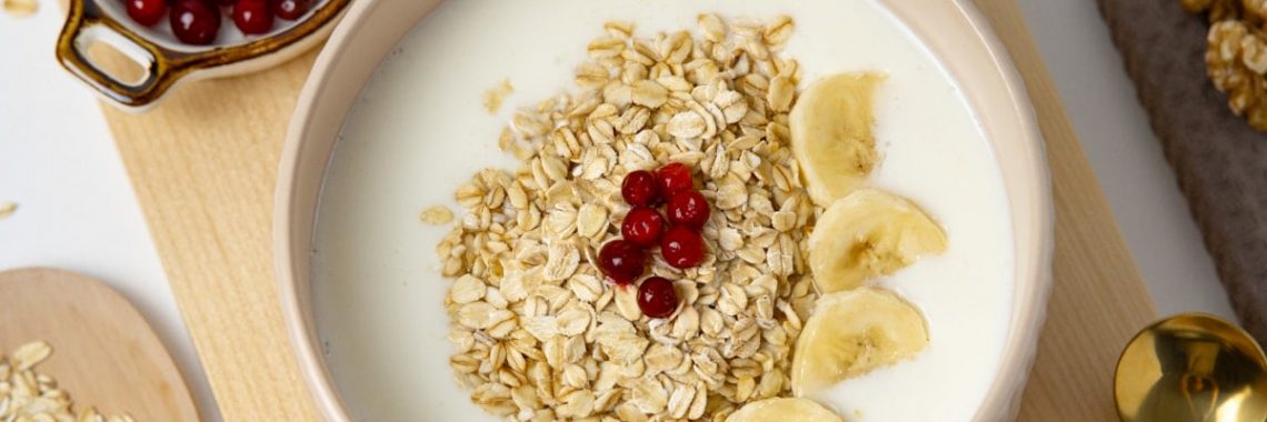 a bowl of oatmeal with bananas and cherries